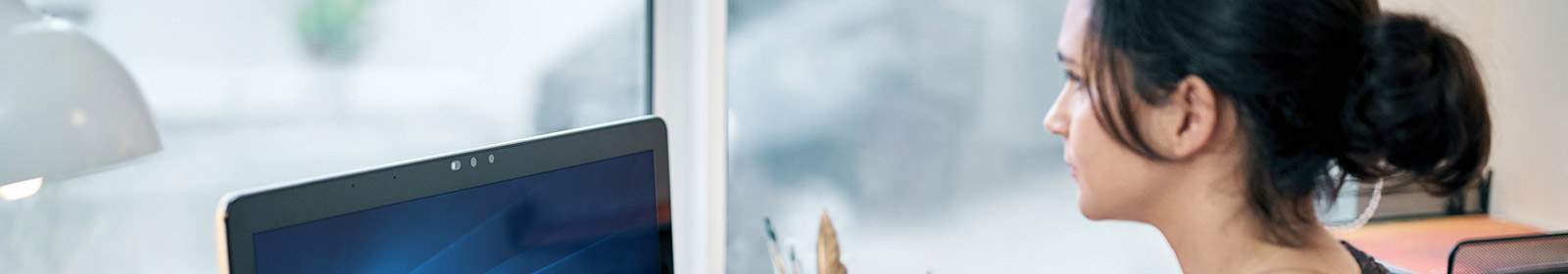 Woman sitting at desk working on desktop computer