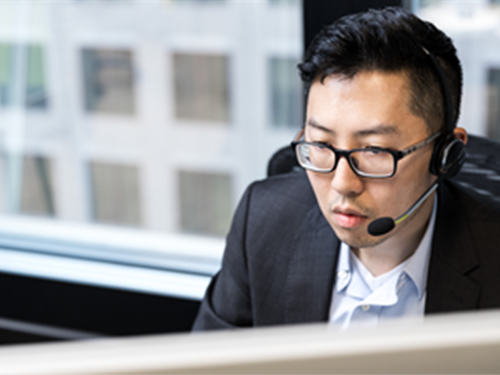Asian man with a headset on a call
