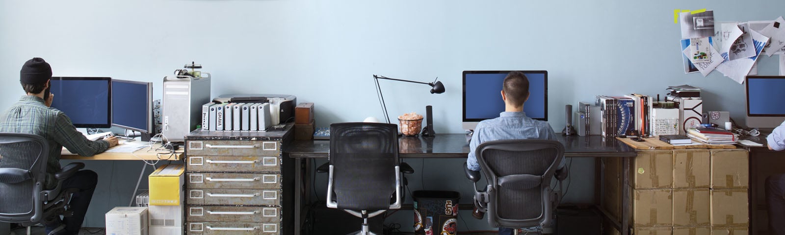 A group of people in a room working behind their desk