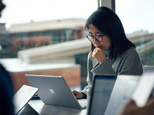 Female with glasses looking at her laptop screen