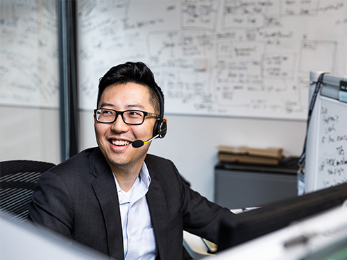 Asian man wearing headset and smiling 