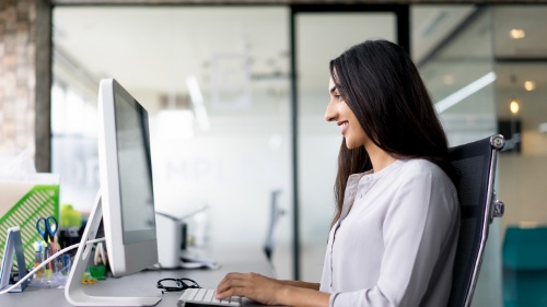 A woman is working on the desktop