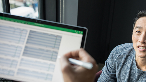 man looking at someone working on tablet