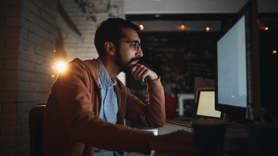 man working on laptop at night