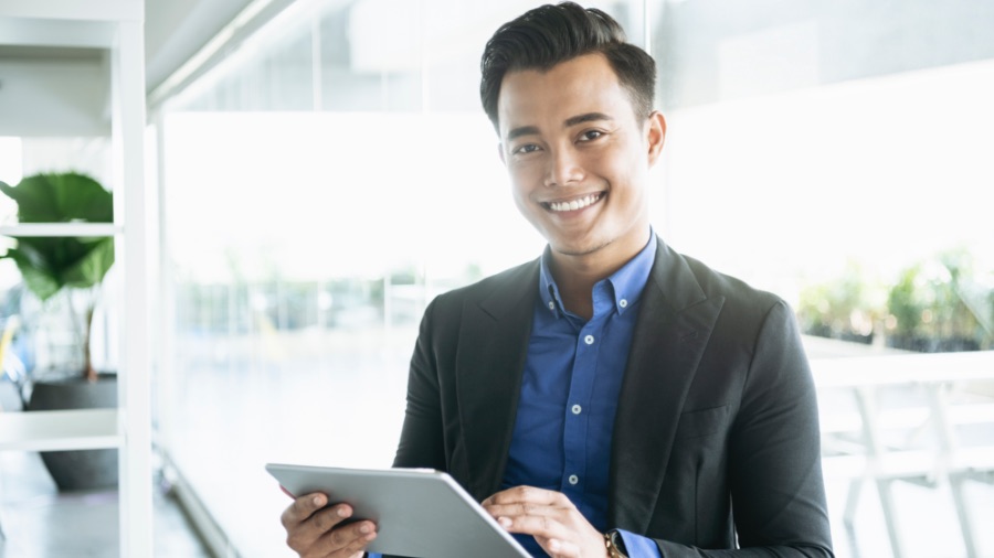 man smiling and working on tablet