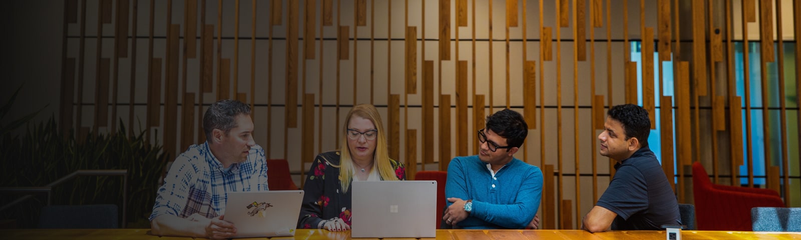 A group of tech workers hold meeting in common space of the office