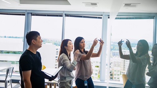 A group of people standing next to a board