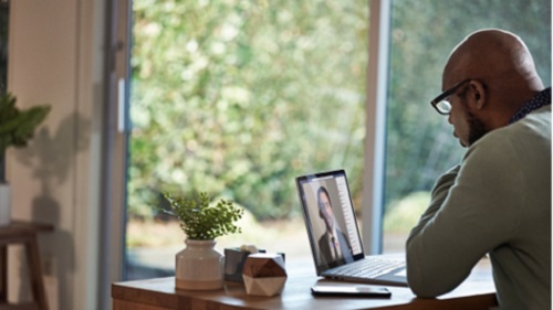 A man with his laptop attending a Teams meeting