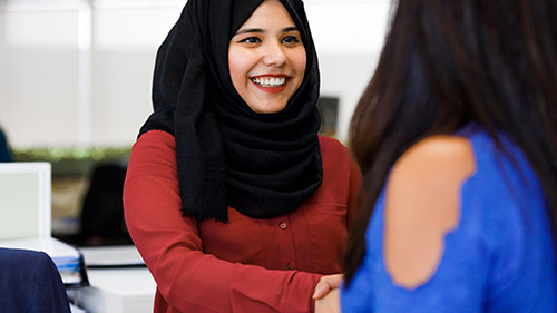 Two women are shaking hands