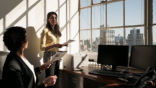 women discussing on papers