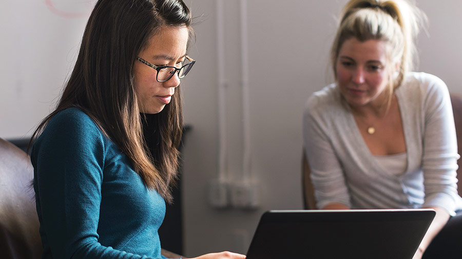 two women working on laptop