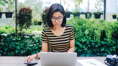 girl working on laptop in garden
