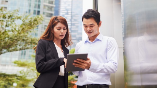 man and woman working on tablet