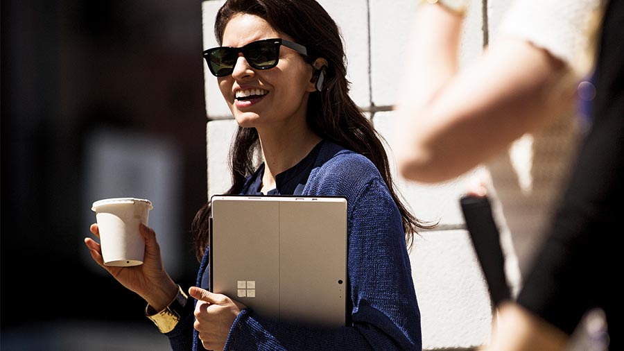 women holding laptop and a coffee cup