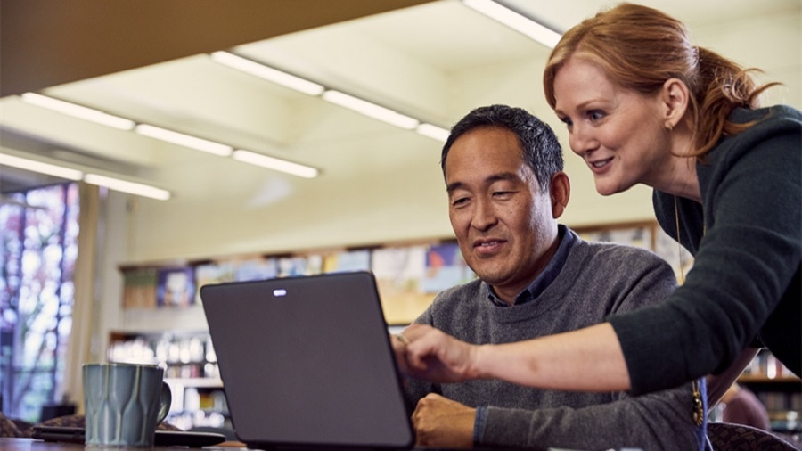 man and woman discussing in laptop