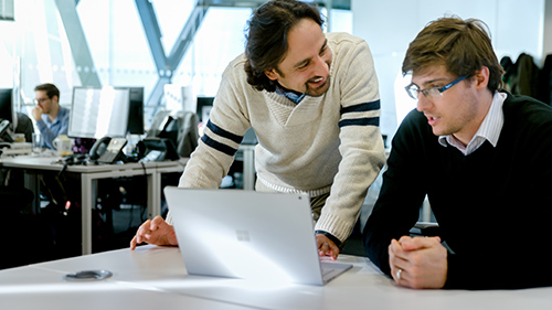 Two men working on laptop