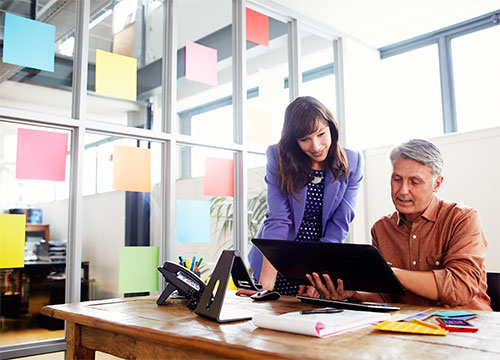 Man and woman working on tablet at desk