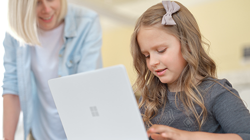 Una niña y una mujer delante de un ordenador