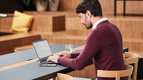 Hombre trabajando en una mesa con un portátil