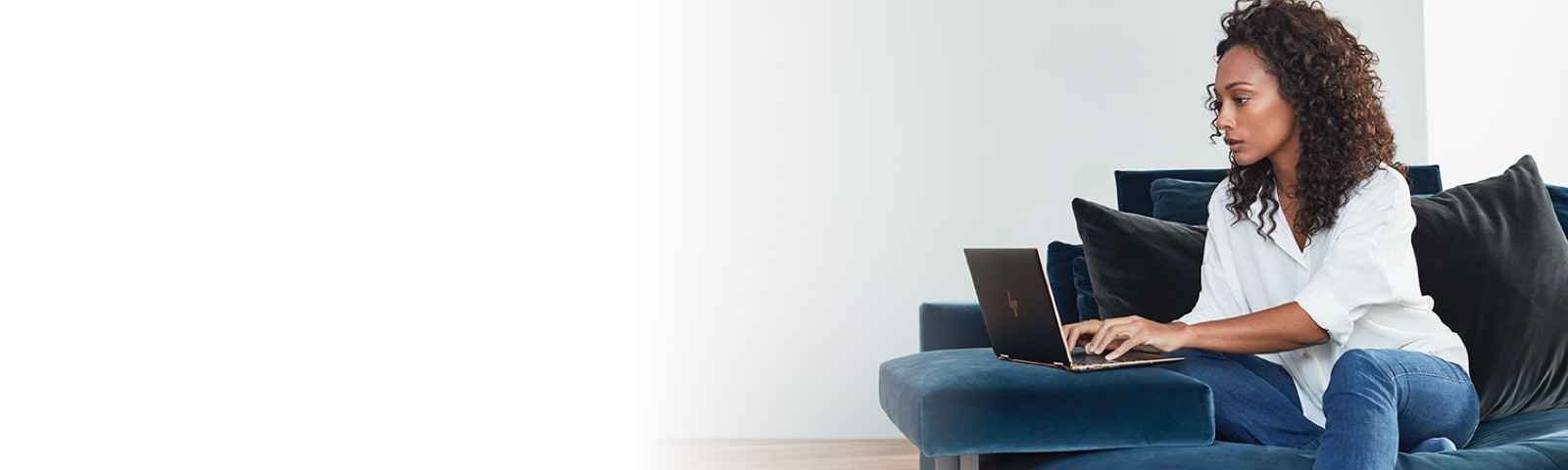 Person with serious expression working on laptop