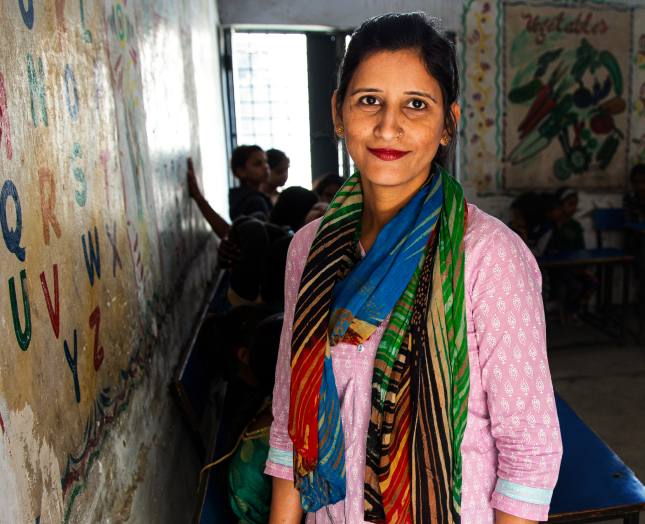 Brightly dressed woman smiles while children play at home