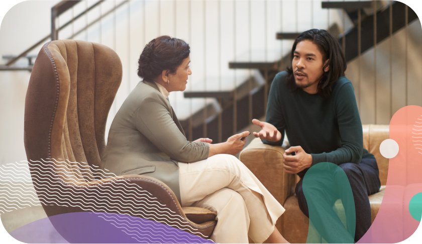 Two people in conversation on office sofas