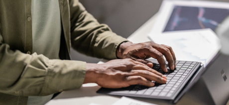 Person’s hands typing on a keyboard