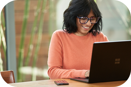 A person looking at a laptop and smiling