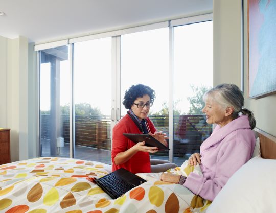 A woman showing Microsoft Azure on a tablet to another woman