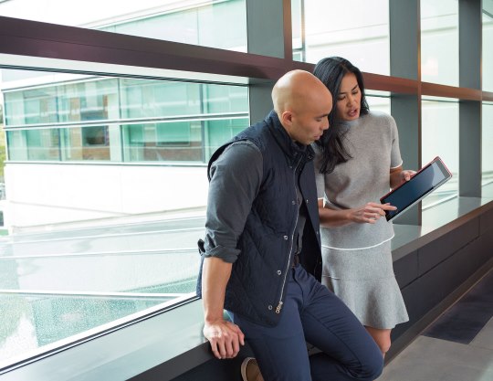 A man and a woman look over a tablet using Microsoft Azure