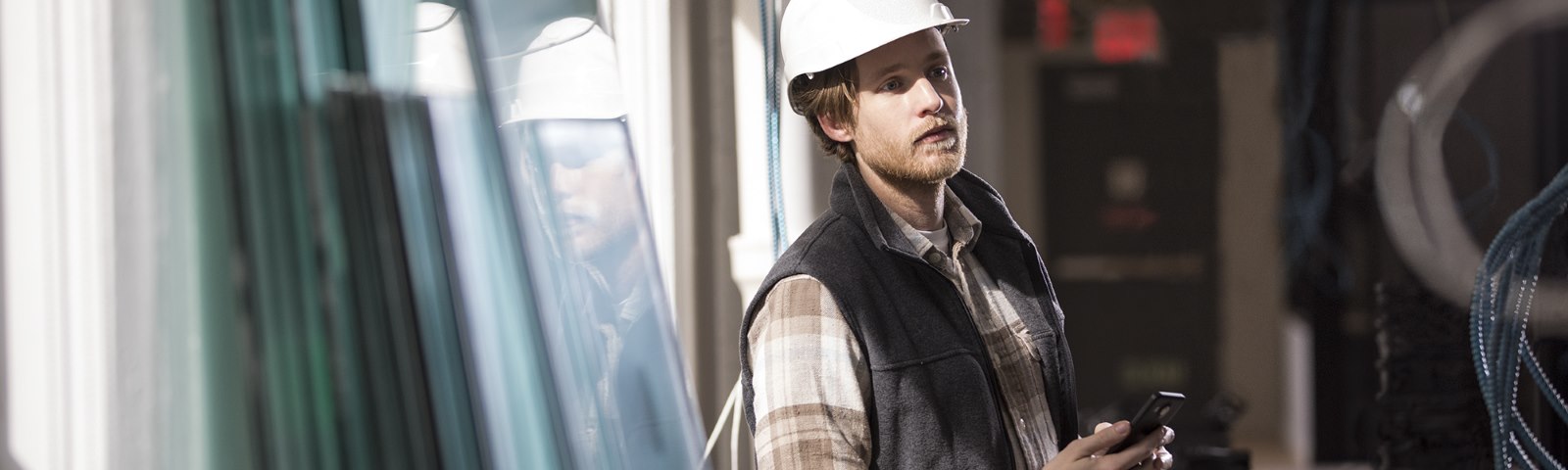 A man in a hard hat holds a Microsoft phone