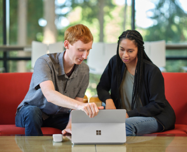 One professional presents to another on a laptop