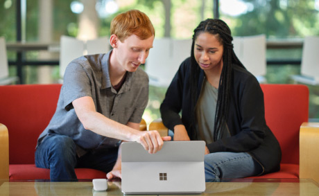 One professional presents to another on a laptop