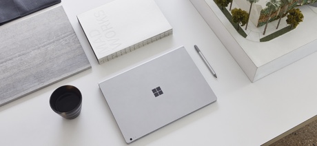 Microsoft Surface laptop on a table next to a cup of coffee