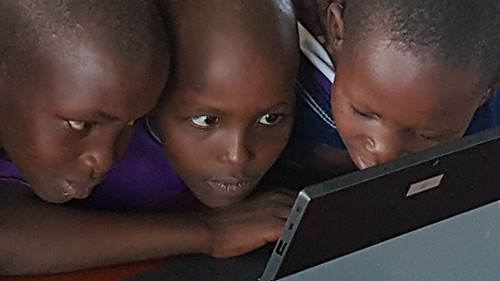 Three children gathered around Microsoft Surface