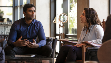 Two colleagues sitting together and talking.
