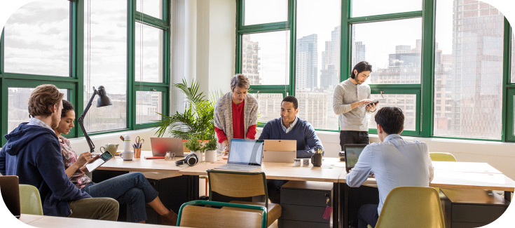 A team works in an open office space with a city view