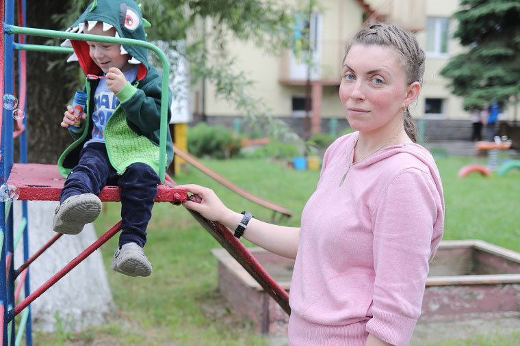 A parent plays with a child at a playground