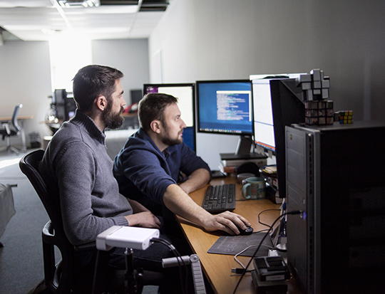 Two men sat by computers