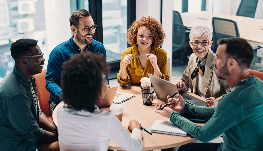 Six coworkers chat around a table