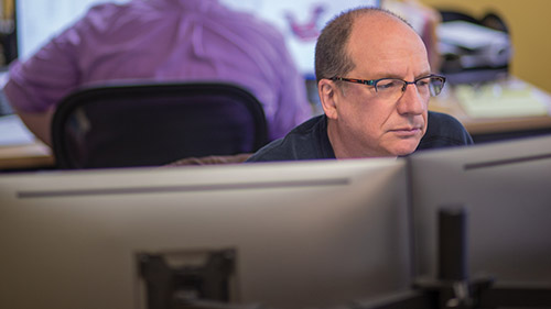 Man working at multi-monitor computer
