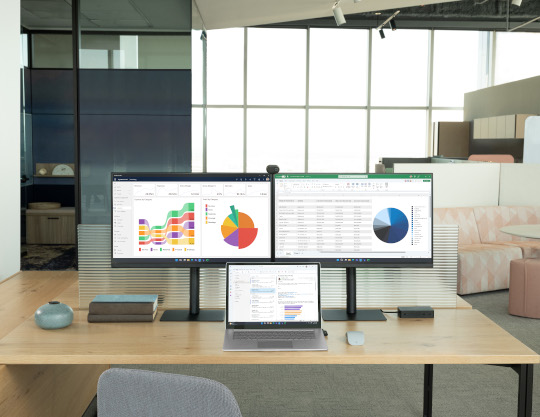 Office Desk with Laptop and two screens showing Dynamics 365