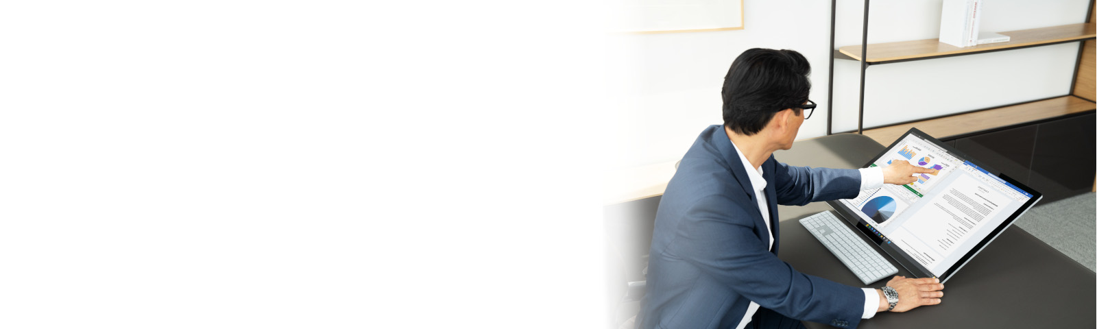 Man sitting at his office desk working on a Surface Studio 2