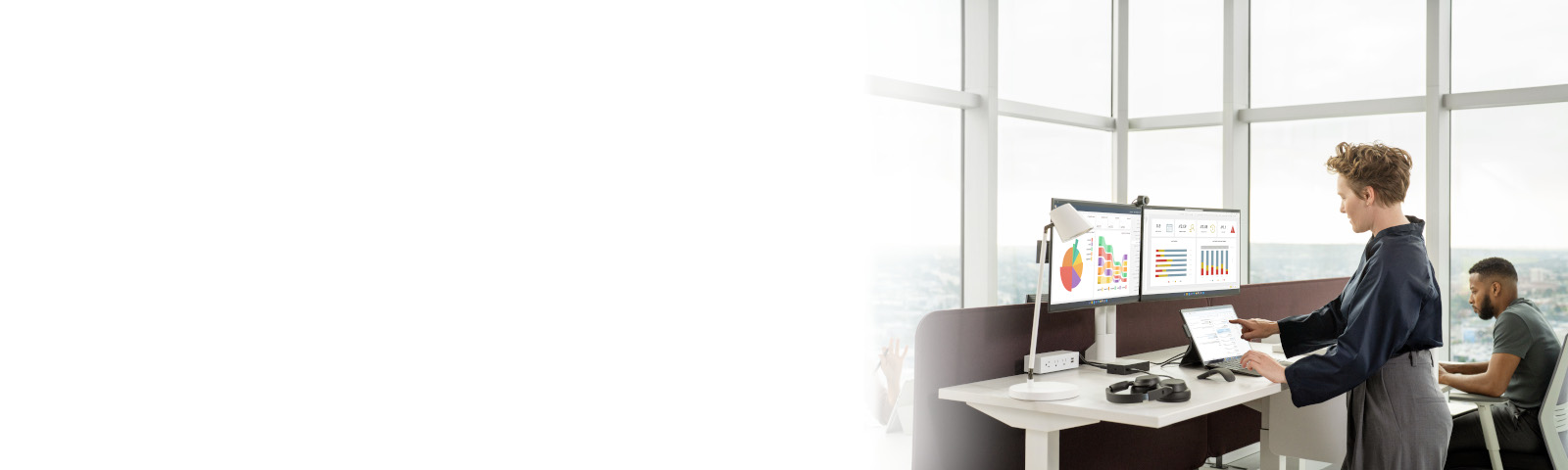 Woman standing at a desk in the office working on a Surface Pro 9