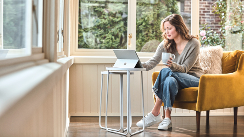 Woman interacting with a Surface Pro laptop at home