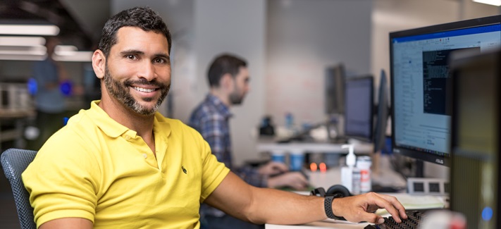 A smiling developer at his computer