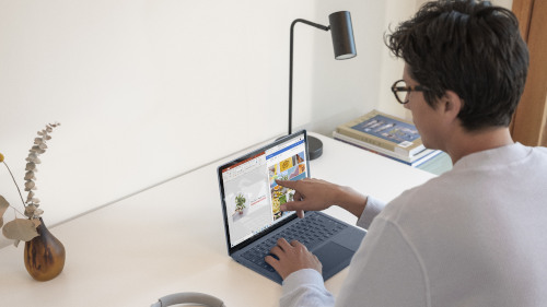 Ein Mann arbeitet an einem Laptop und zeigt auf den Bildschirm