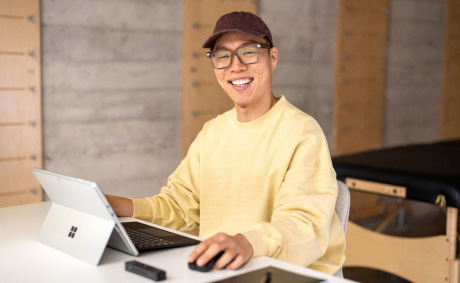 A happy professional works on a laptop