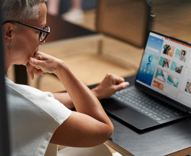 A woman looking at a presentation on her laptop’s screen