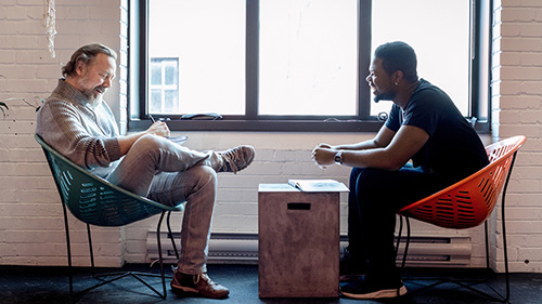 Two men talking in chairs